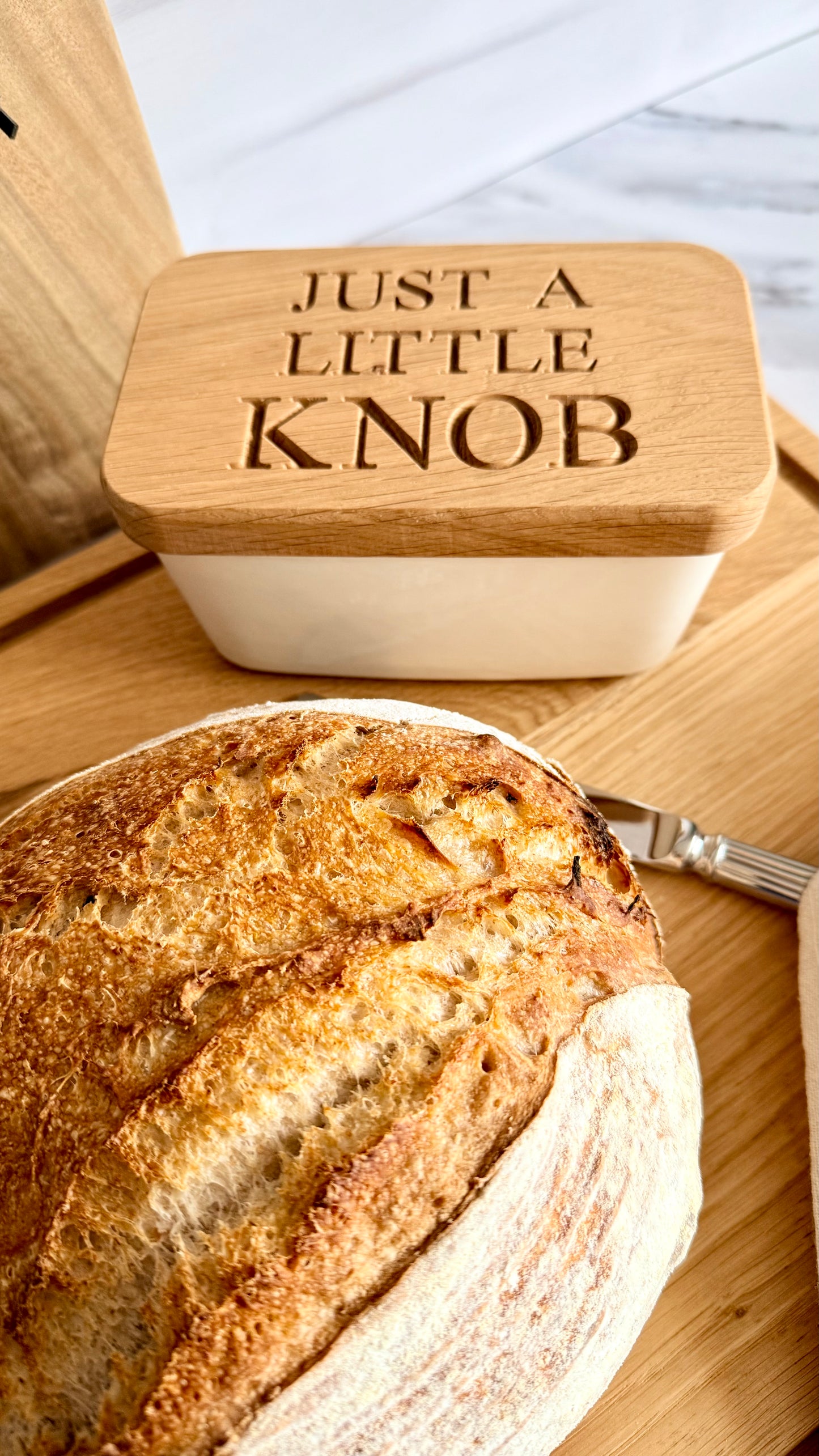 Bread with a container labeled 'Just a Little Knob' on a wooden surface.