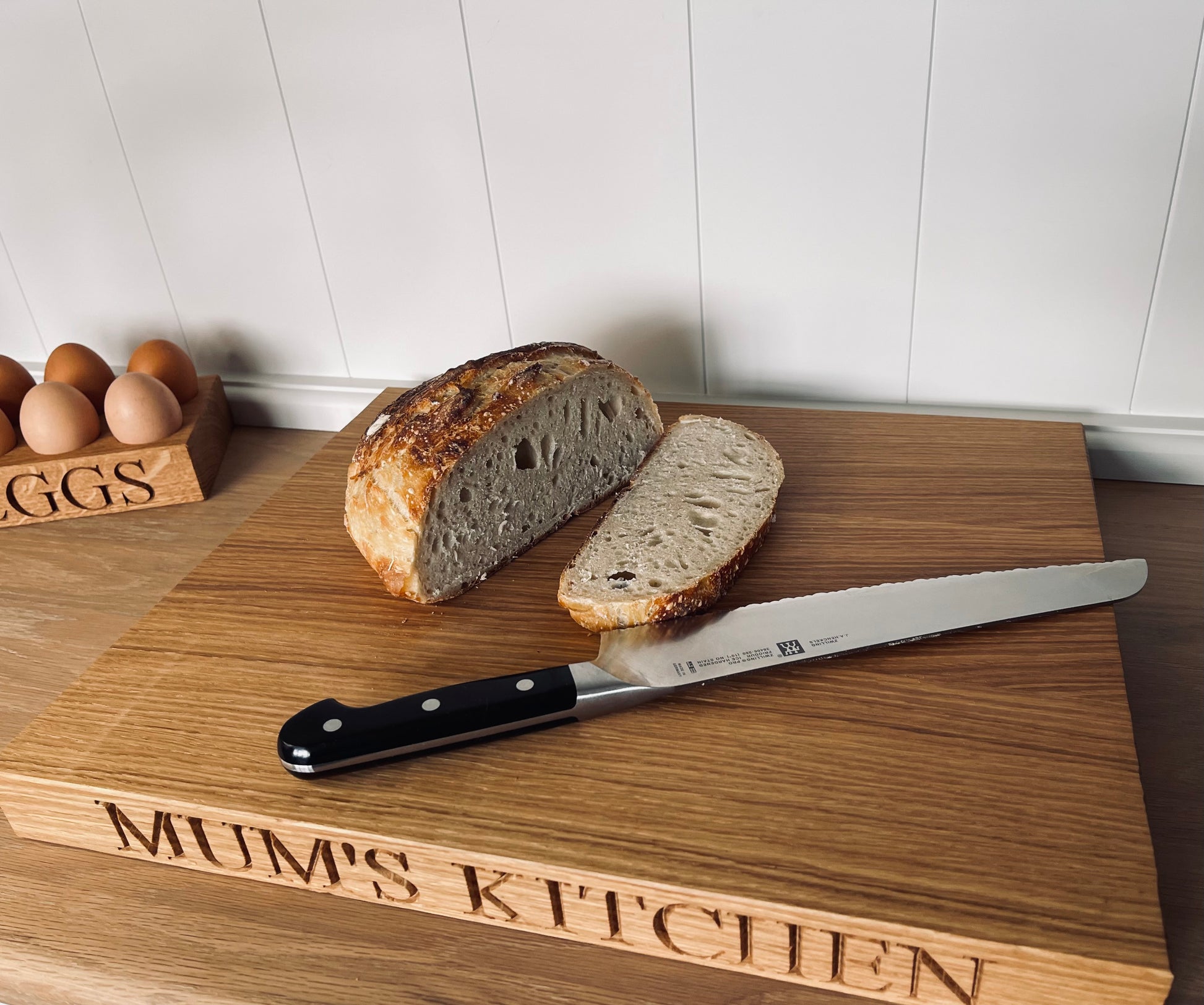 Personalised large oak chopping board With egg holder near it 